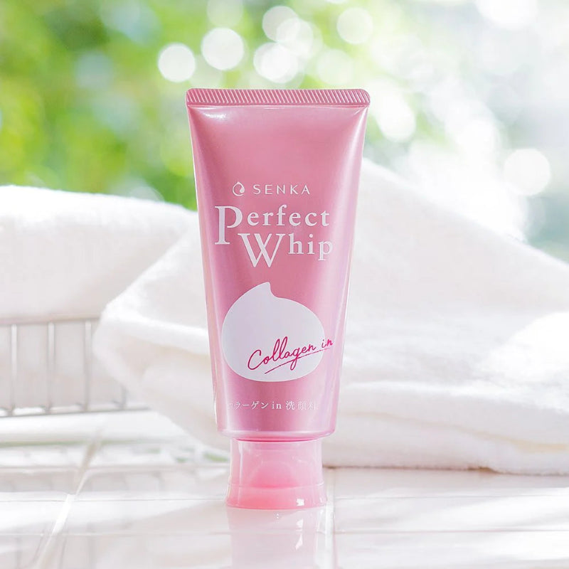 Pink tube of Senka Perfect Whip with a blurred green and white background