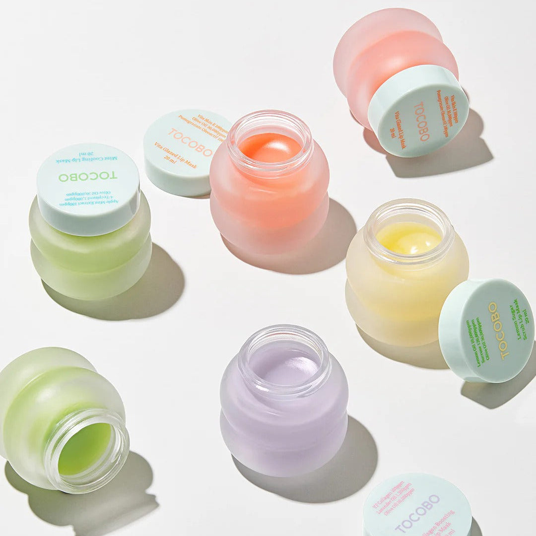 Set of small jars with colorful contents on a white background