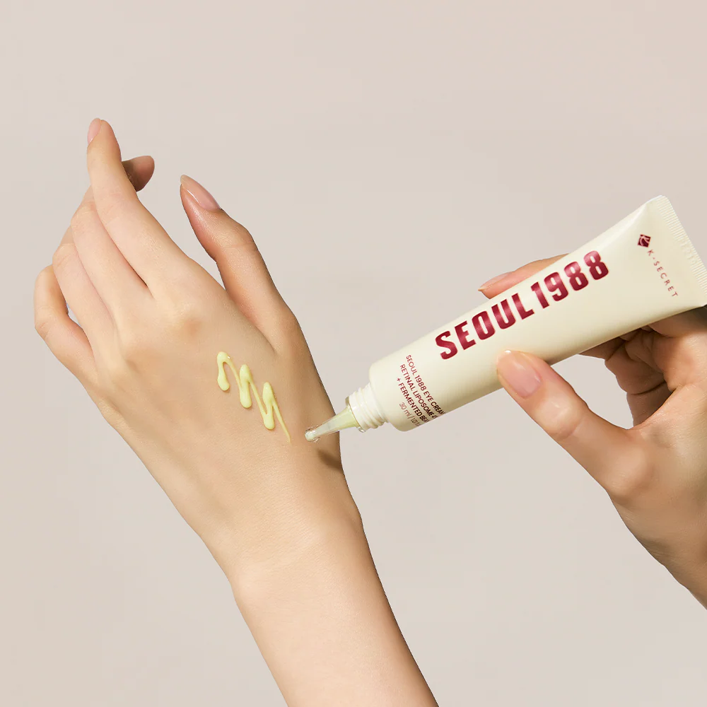 Hand applying cream from a 'Seoul 1988' tube to a wrist with a beige background