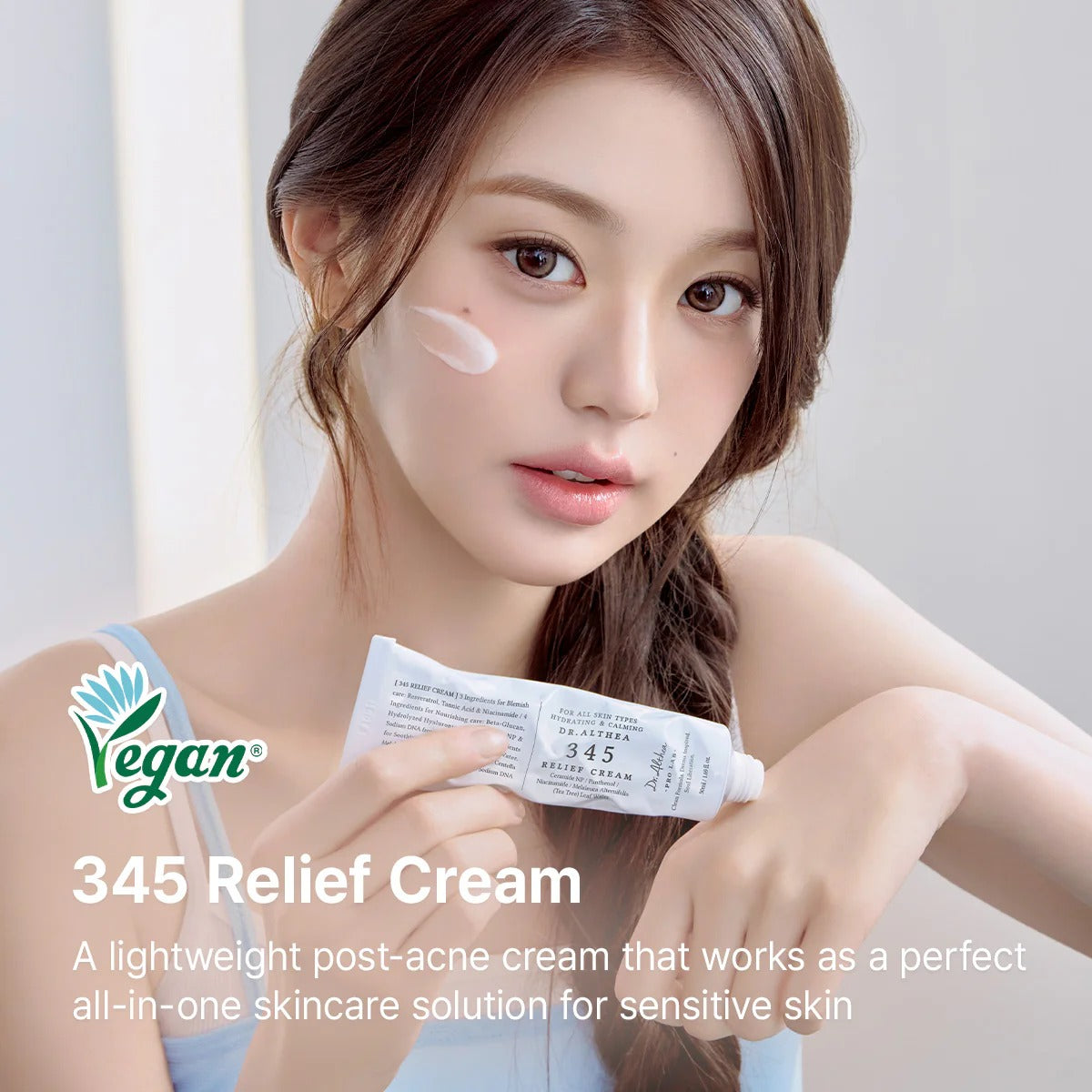 Woman holding 345 Relief Cream with a Vegan logo on a light background