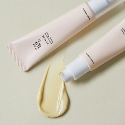 Two tubes of cream with a swatch on a light green background