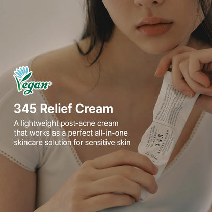 Woman holding a tube of 345 Relief Cream with a Vegan label on a blurred background