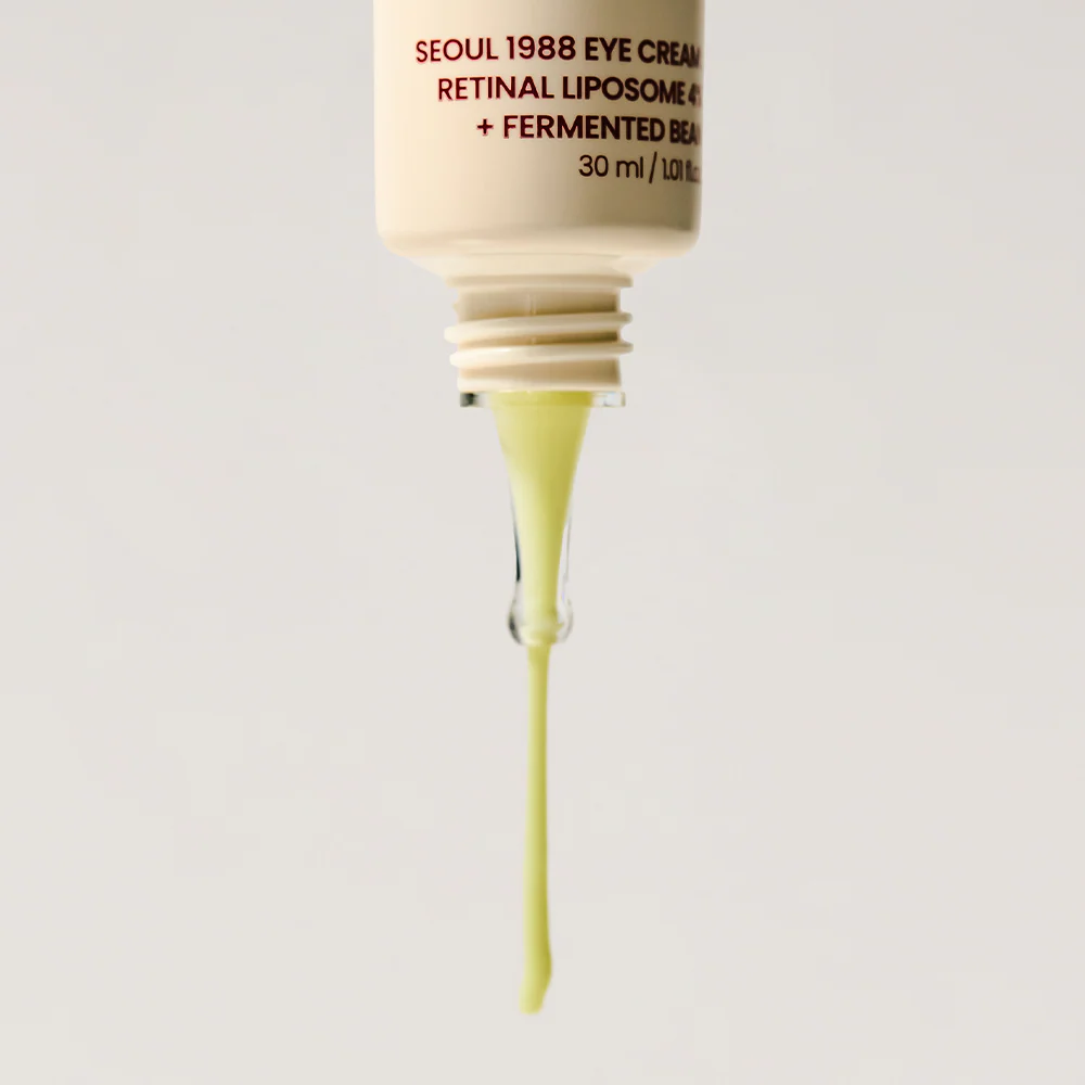 Skincare dropper with yellow liquid and visible brand text on a light gray background