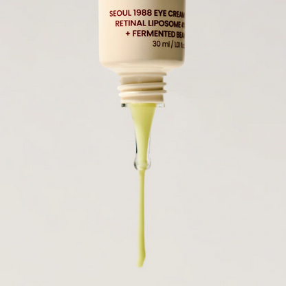 Skincare dropper with yellow liquid and visible brand text on a light gray background