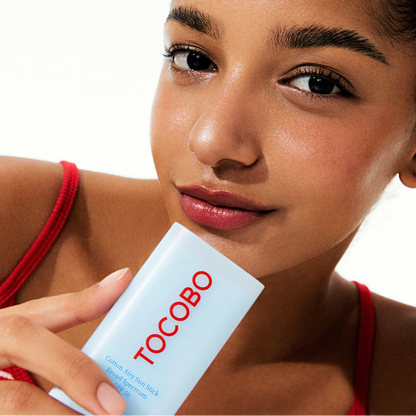 Woman holding a Tocobo product against a white background