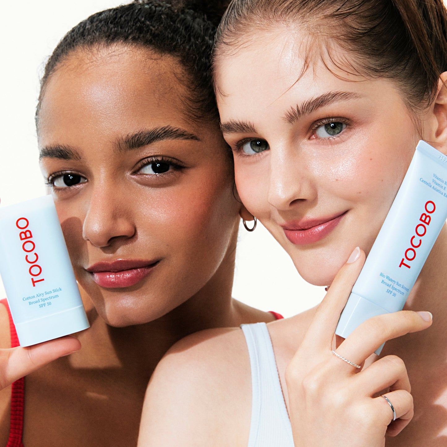 Two women holding Tocobo skincare products against a neutral background
